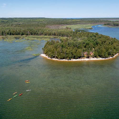 Aerial view of an island and kayakers