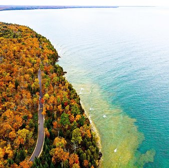 Aerial view ofrees in their autumn colors along the lakefront from above