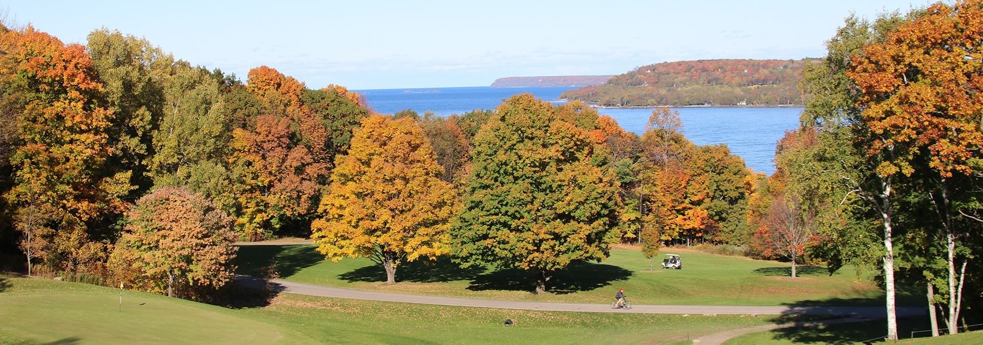 Where to Host a Reunion in Door County A golf course surrounded by colorful trees and the lake in the distance.