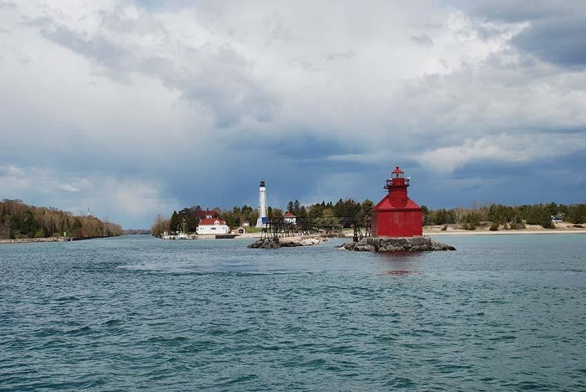 Lighthouses A red lighthouse on the lake at the end of a pier.