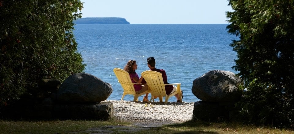 Weddings Couple sitting in chairs at the lakefront