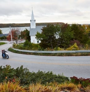 Weddings A white church with a steeple in the distance beyond a road.