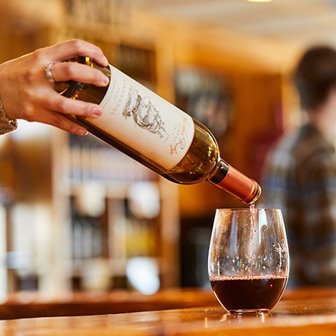 Pouring a glass of red wine from the bottle