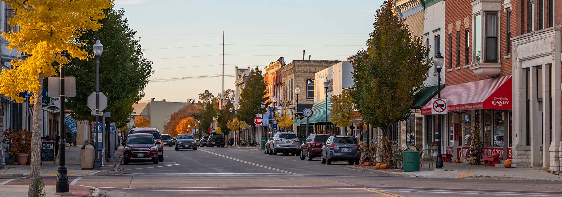 Looking down a street lined with buildings and parked cars