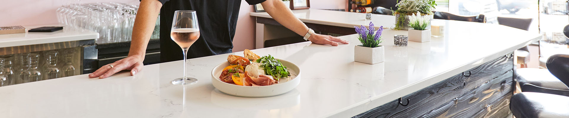 Food and a glass of wine on a bar top