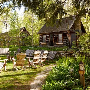 Chairs lined up outside of wooden cabins.