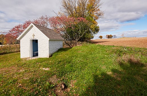 Small white stone chapel.