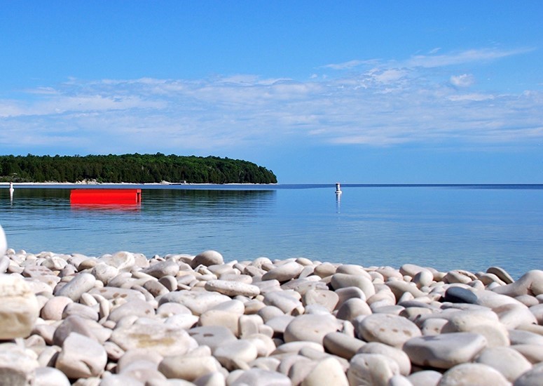 Closeup of a smooth stone beach shoreline.