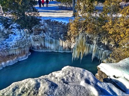 Aerial view looking down at a water inlet and icicles along the cliffside