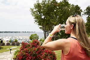 A woman drinking wine near the marina.