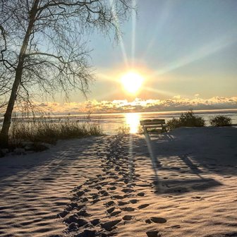 Sunrise over footsteps on a beach