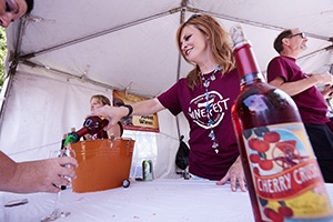 A woman pouring wine into a glass.