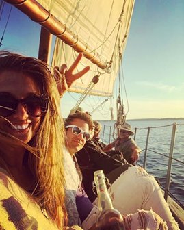 People smiling on a sailboat.