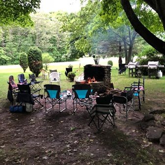 Empty chairs around a fire.