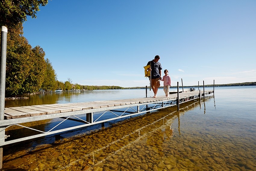 Fishing A man and a child walking down a dock after fishing.